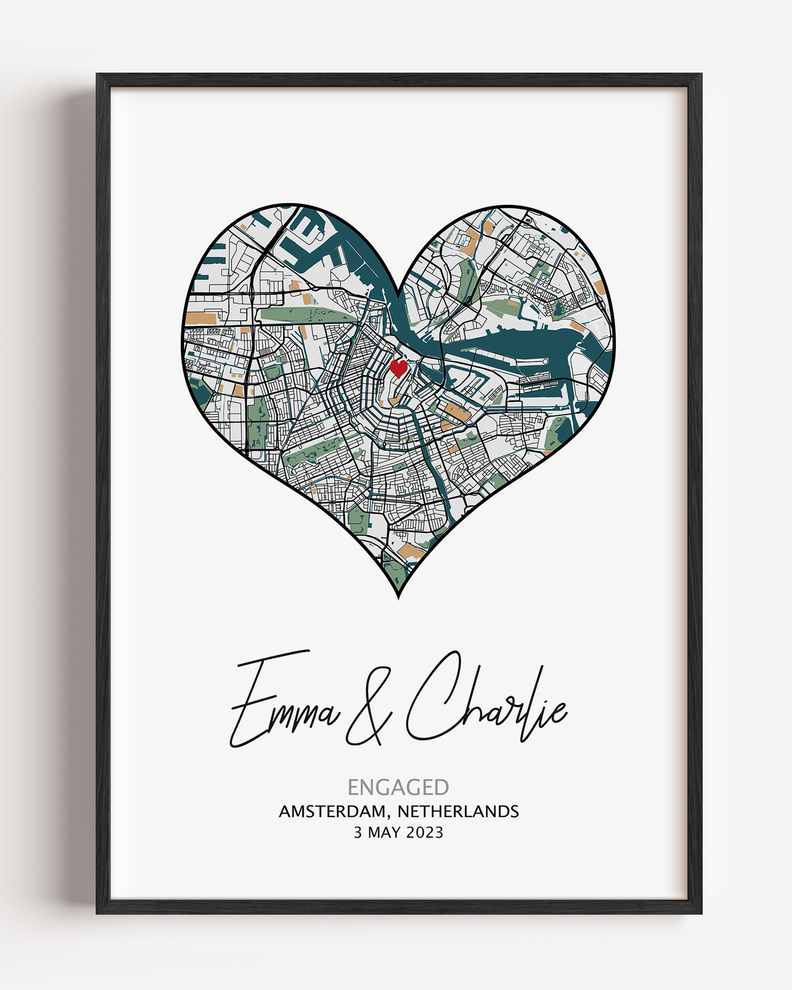 Heart-shaped engagement map print with a red heart marking the proposal location, customized with couple’s names and date in elegant script below the map on a white background.