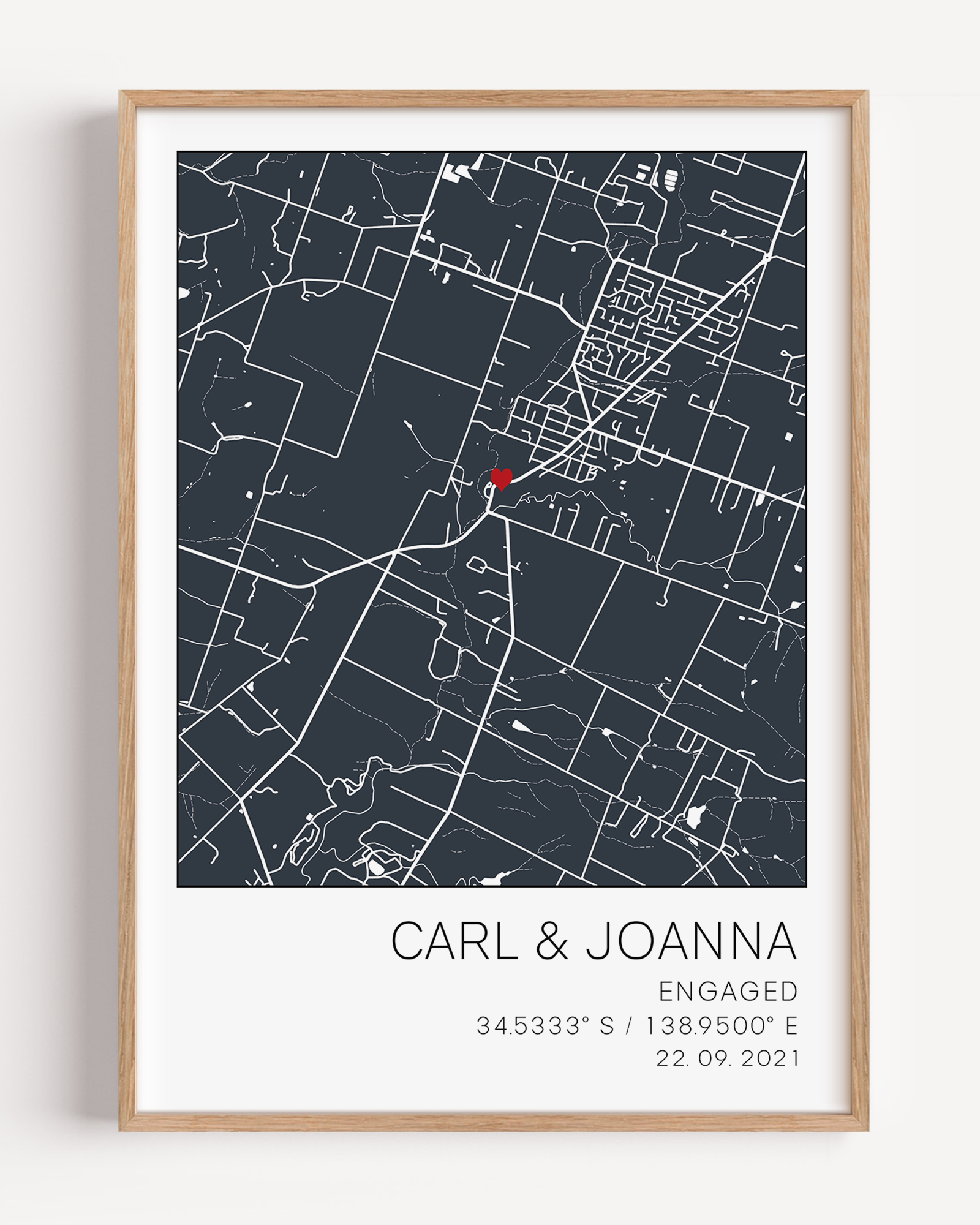 Modern framed engagement map print featuring minimalist black street lines with a red heart pinpoint marking the proposal location, personalized with couple’s names and engagement date in elegant script”