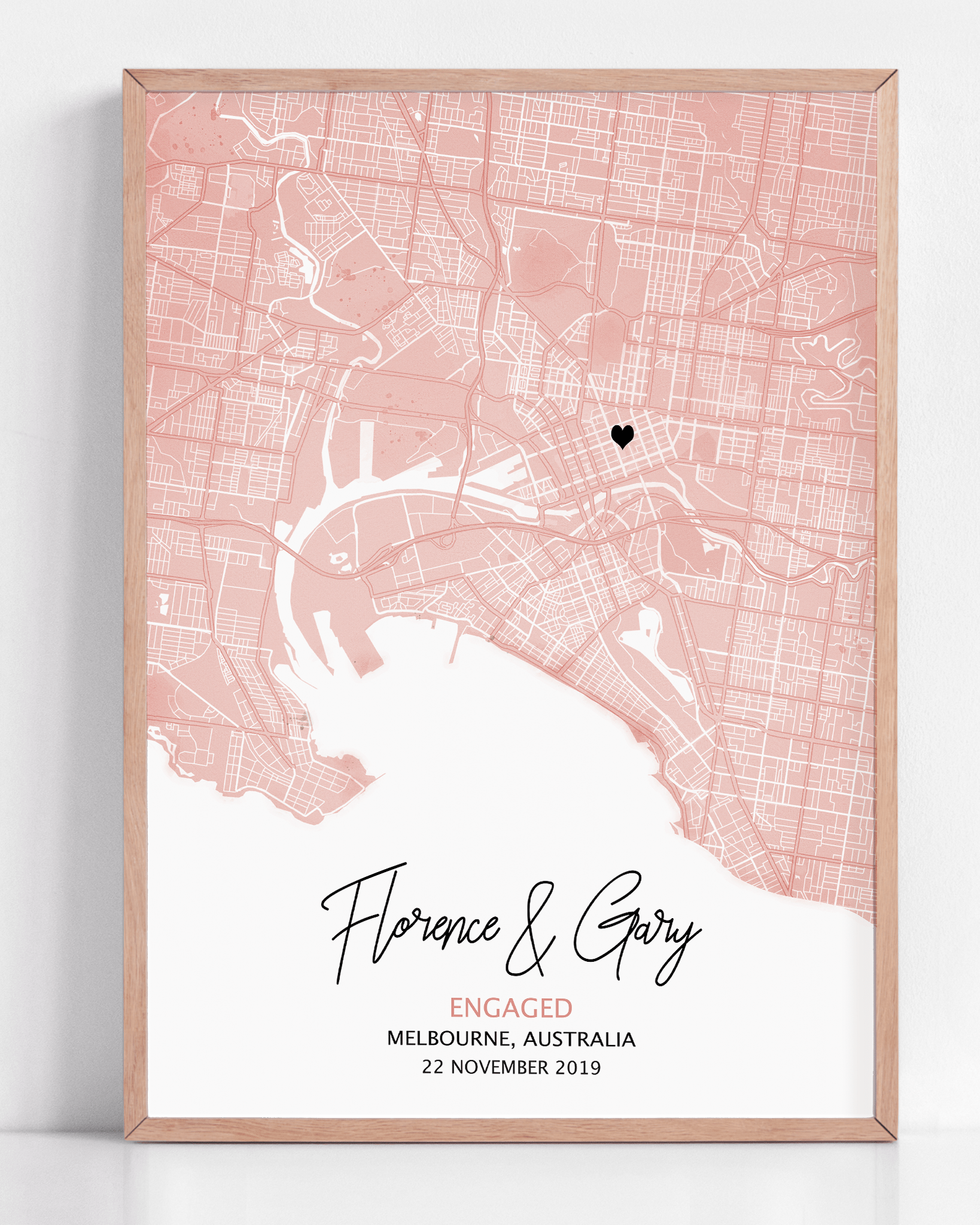 Modern pastel colour map print with light grey streets and a red heart marking a special location, customized with couple’s names and engagement date in elegant script below.