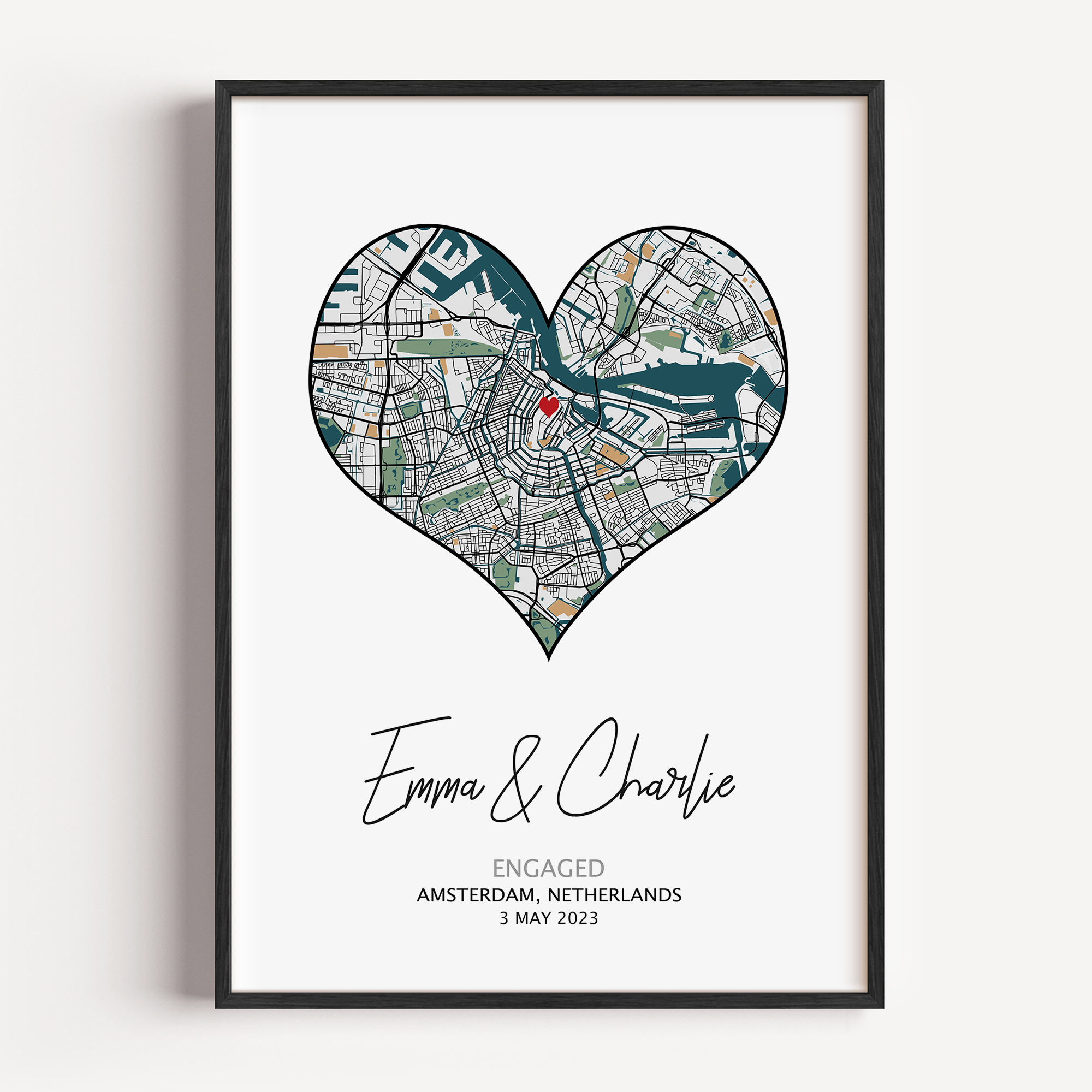Heart-shaped engagement map print with a red heart marking the proposal location, customized with couple’s names and date in elegant script below the map on a white background.