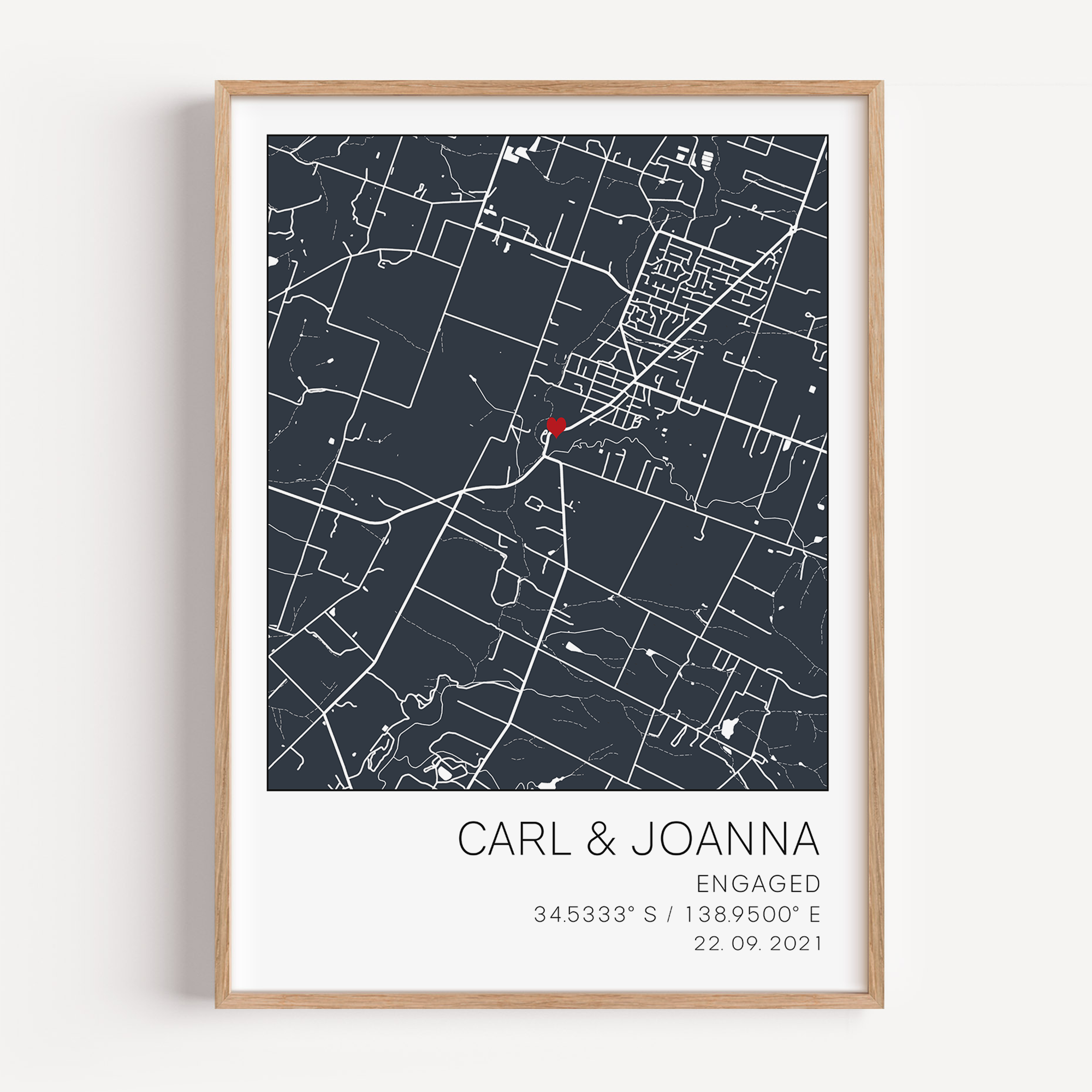 Modern framed engagement map print featuring minimalist black street lines with a red heart pinpoint marking the proposal location, personalized with couple’s names and engagement date in elegant script”