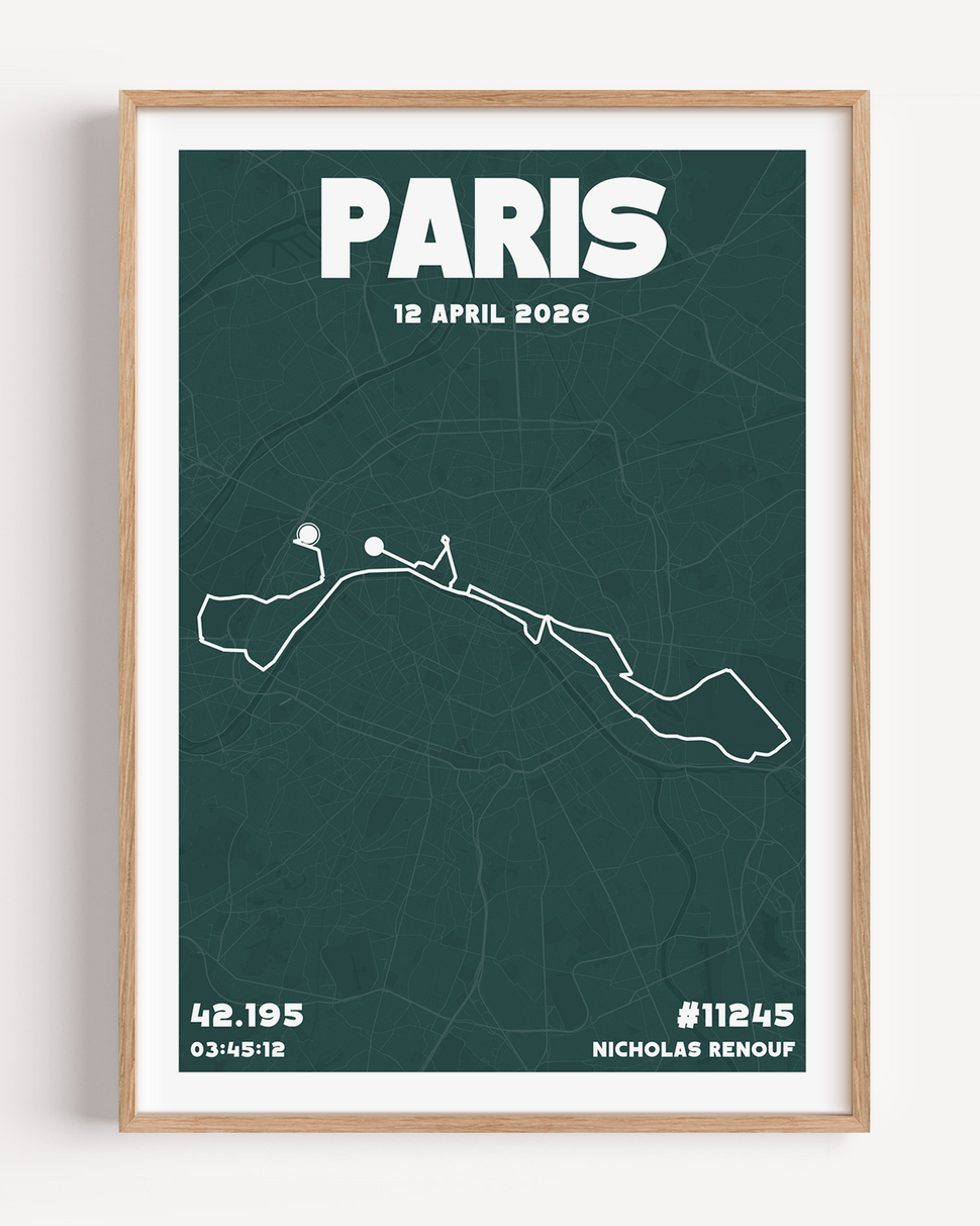A framed Paris Marathon Urban Edition print in a light wood frame. The design features a deep forest green background with a white marathon route overlay, bold block typography at the top saying PARIS, and personal race stats like finish time and bib number at the bottom.
